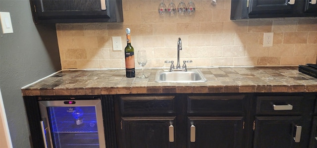 kitchen with sink, beverage cooler, and tasteful backsplash