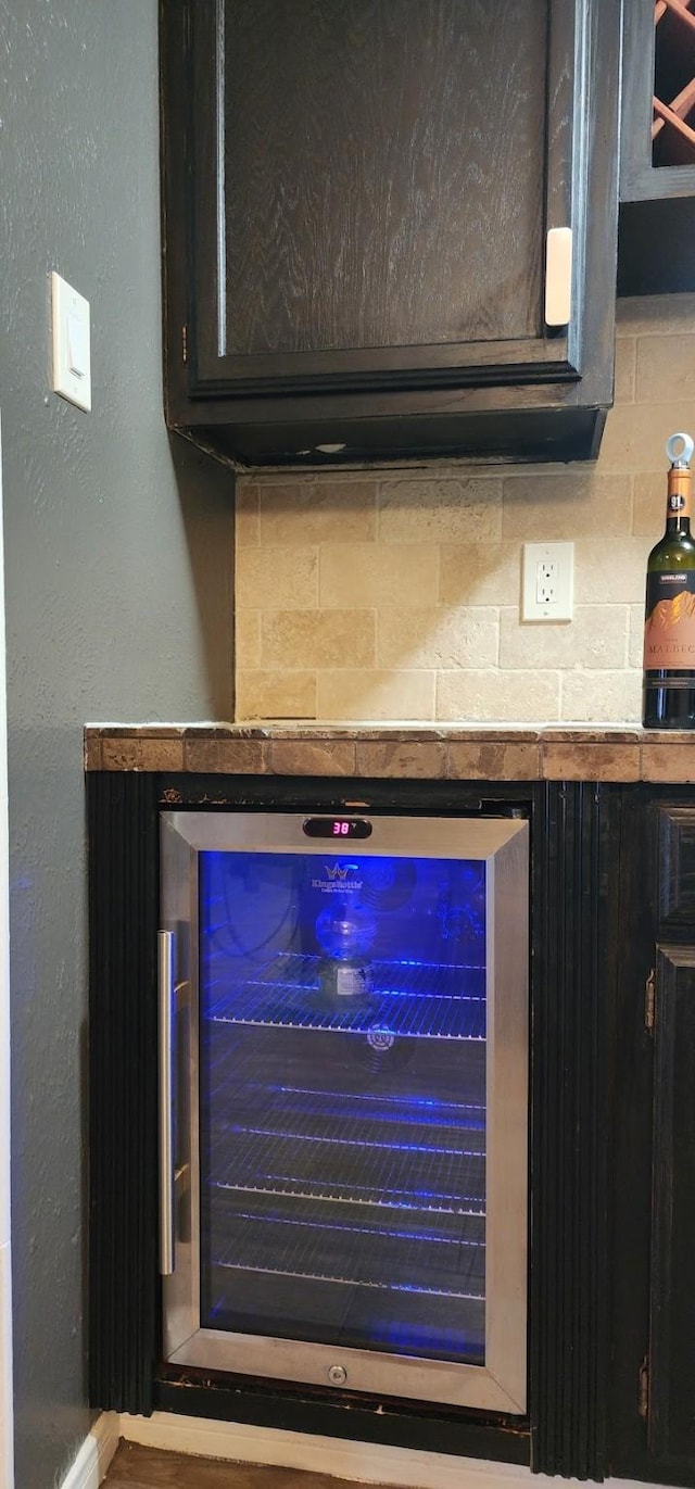 interior details featuring wine cooler, decorative backsplash, and indoor bar