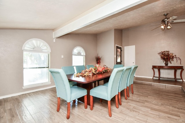 dining area with light wood-type flooring, beamed ceiling, and ceiling fan