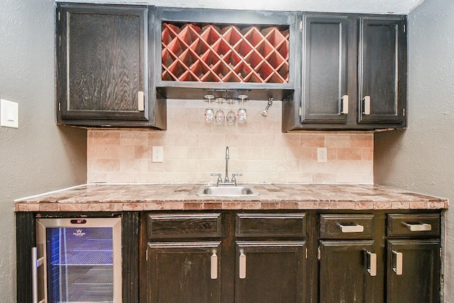 bar featuring sink, backsplash, and wine cooler