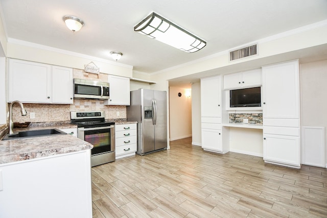 kitchen with sink, light wood-type flooring, white cabinetry, stainless steel appliances, and tasteful backsplash