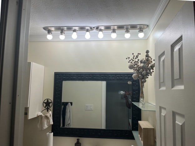 bathroom with crown molding and a textured ceiling