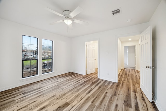 empty room with ceiling fan and light hardwood / wood-style floors