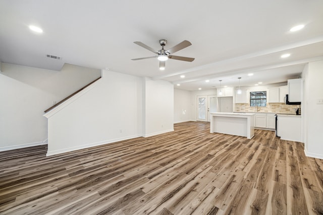 unfurnished living room featuring wood-type flooring and ceiling fan