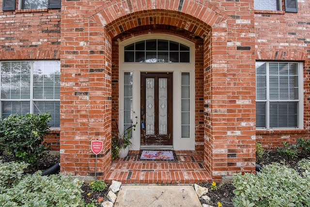 view of exterior entry with brick siding