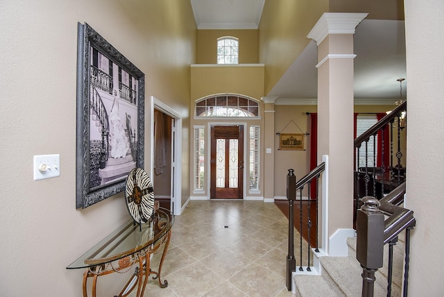 entrance foyer with light tile patterned flooring, baseboards, stairs, ornamental molding, and ornate columns