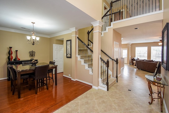 dining area featuring crown molding, ornate columns, visible vents, baseboards, and stairs