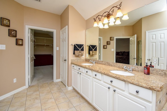 bathroom with double vanity, a notable chandelier, a sink, and tile patterned floors