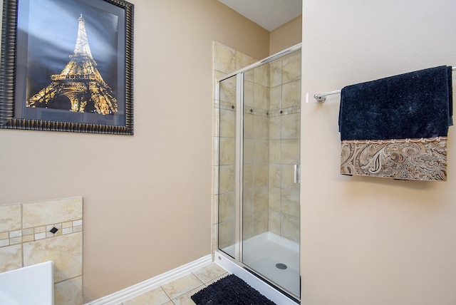 bathroom featuring a stall shower, tile patterned flooring, and baseboards