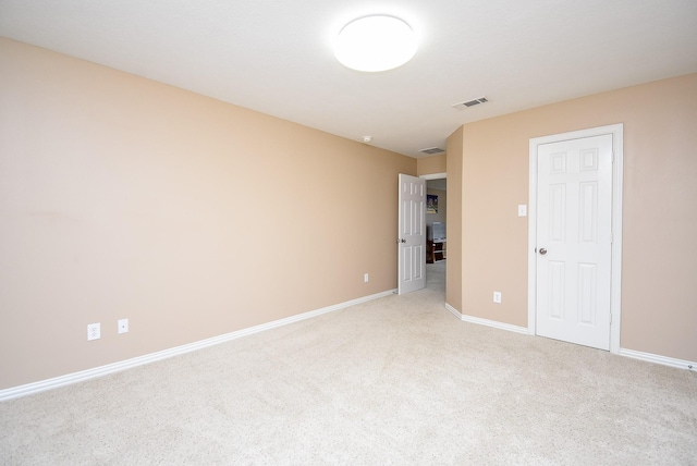 unfurnished room with light colored carpet, visible vents, and baseboards