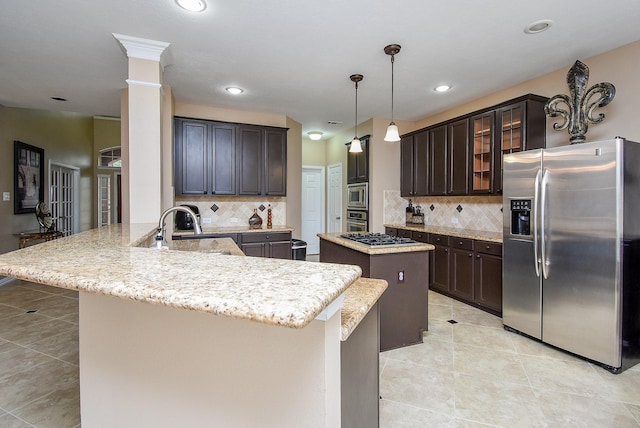 kitchen featuring glass insert cabinets, dark brown cabinetry, appliances with stainless steel finishes, and a center island