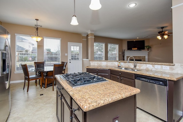 kitchen featuring stainless steel appliances, pendant lighting, a sink, and dark brown cabinets