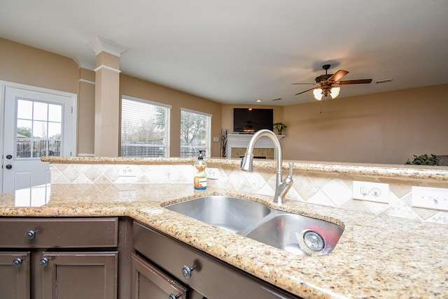 kitchen with light stone countertops, a sink, visible vents, and a healthy amount of sunlight