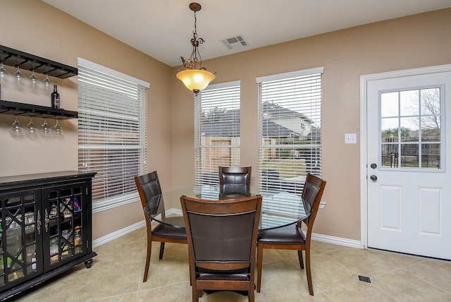 dining area featuring a healthy amount of sunlight, visible vents, and light tile patterned floors