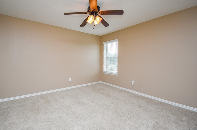 spare room featuring carpet, ceiling fan, and baseboards