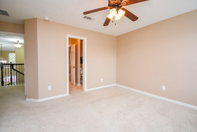 spare room featuring light carpet, baseboards, and visible vents