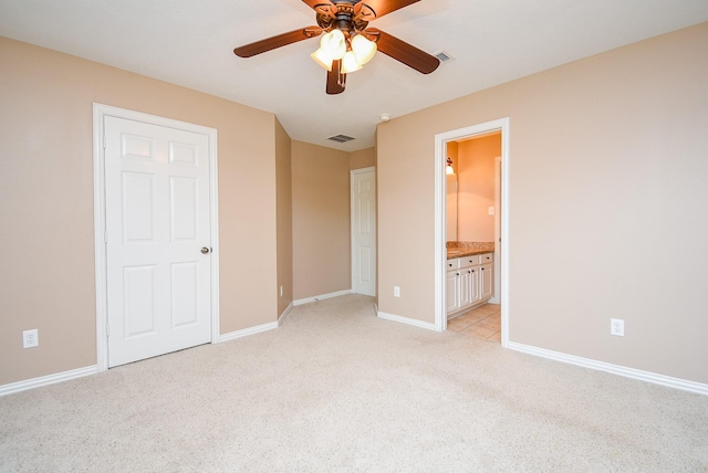 unfurnished bedroom featuring light colored carpet, visible vents, baseboards, and ensuite bathroom