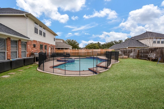 view of swimming pool featuring a fenced backyard, a pool with connected hot tub, and a yard