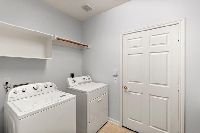 laundry area with light tile patterned flooring and washing machine and clothes dryer