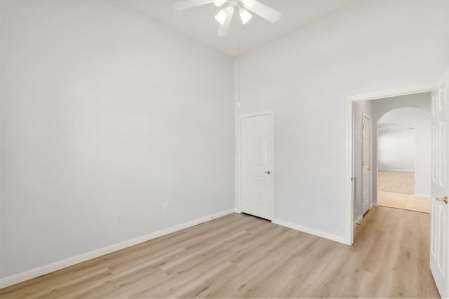 unfurnished room with light hardwood / wood-style flooring, ceiling fan, and a high ceiling