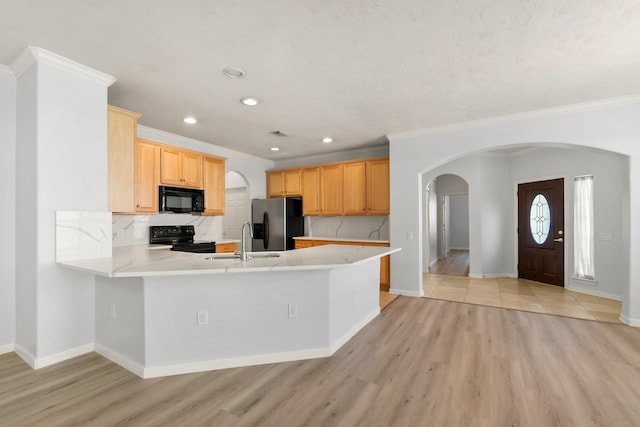 kitchen with sink, light hardwood / wood-style floors, black appliances, light brown cabinets, and kitchen peninsula