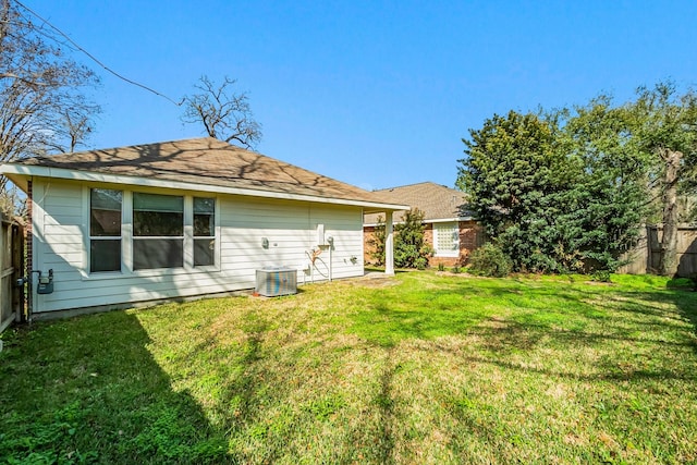 back of property featuring central AC and a yard