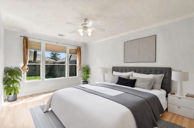 bedroom with ceiling fan, ornamental molding, and light hardwood / wood-style floors