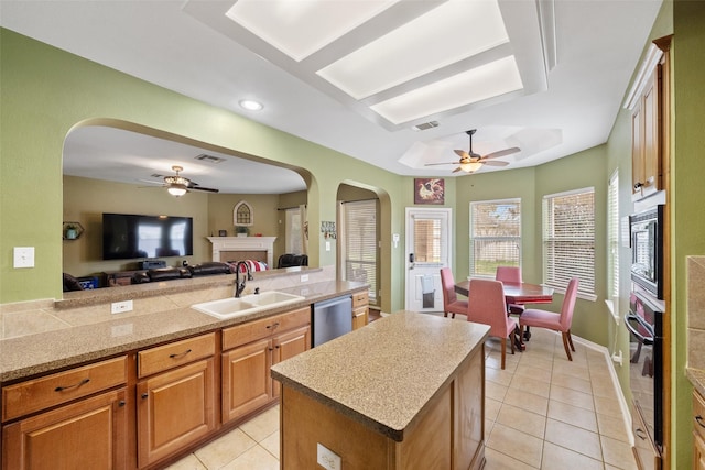 kitchen with built in microwave, sink, a center island, dishwasher, and black oven