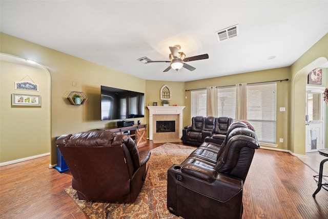 living room with hardwood / wood-style floors, a fireplace, ceiling fan, and plenty of natural light