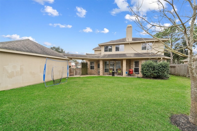 rear view of property featuring a yard and a patio area