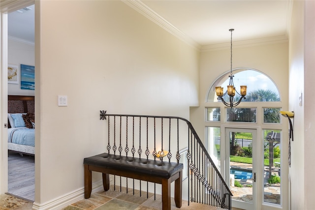 staircase with an inviting chandelier, a towering ceiling, and ornamental molding