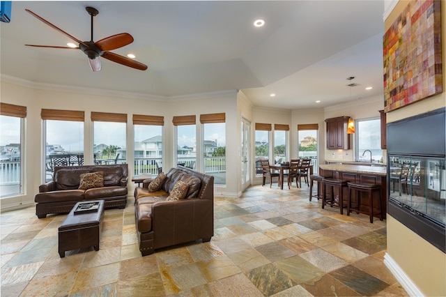 living room featuring ornamental molding and ceiling fan