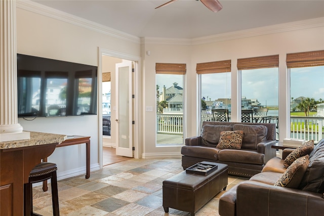 living room with decorative columns, crown molding, a water view, and ceiling fan