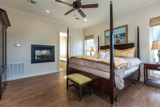 bedroom with multiple windows, dark wood-type flooring, ornamental molding, and a multi sided fireplace