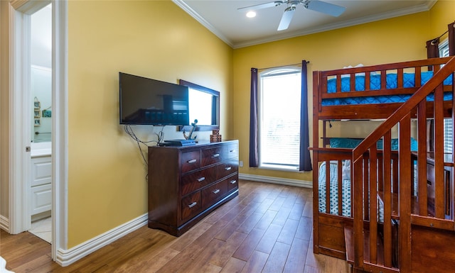 bedroom with ornamental molding, connected bathroom, and hardwood / wood-style floors