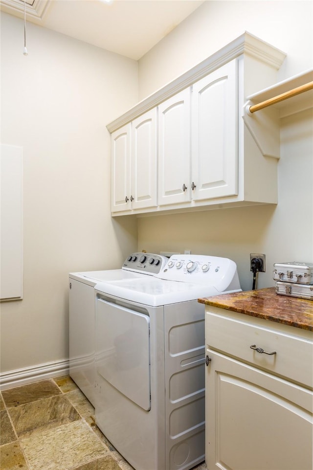 clothes washing area with cabinets and washer and dryer