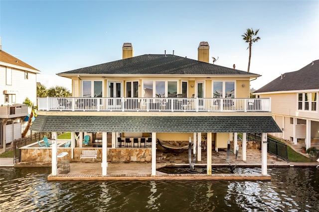 back of property featuring a water view