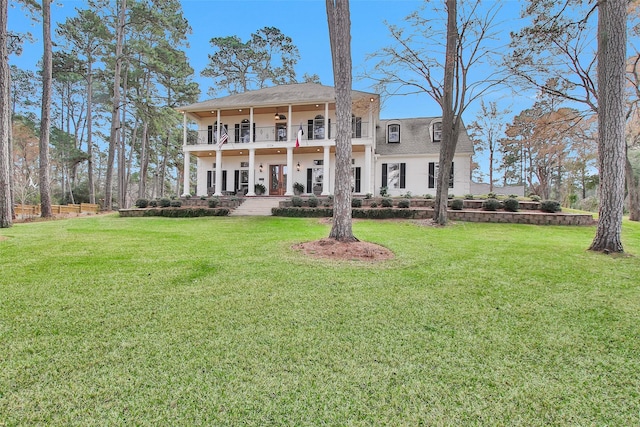 back of property with ceiling fan, a yard, a patio, and a balcony