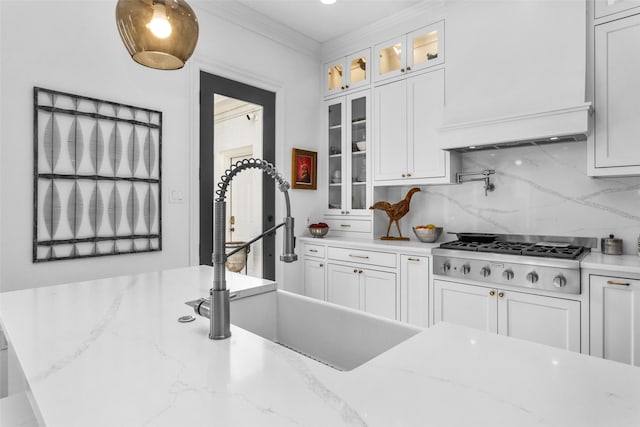 kitchen featuring sink, stainless steel gas cooktop, ornamental molding, decorative backsplash, and white cabinets