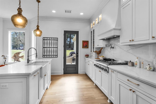 kitchen featuring custom exhaust hood, white cabinetry, and stainless steel gas stovetop