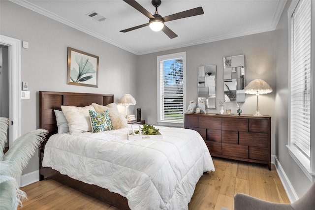 bedroom with crown molding, ceiling fan, and light hardwood / wood-style floors