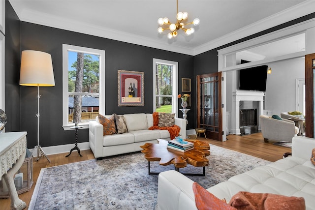 living room featuring hardwood / wood-style flooring, crown molding, plenty of natural light, and a notable chandelier