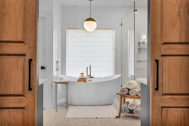 bathroom with tile patterned floors, a tub to relax in, and tile walls