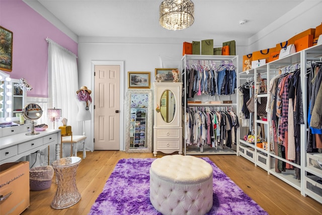 walk in closet featuring a notable chandelier and light wood-type flooring