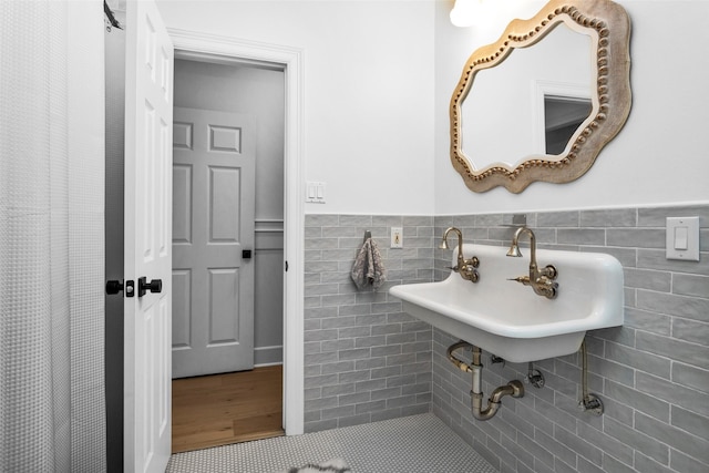 bathroom featuring tile walls and sink