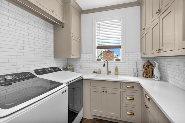 laundry room with cabinets, washing machine and dryer, and sink