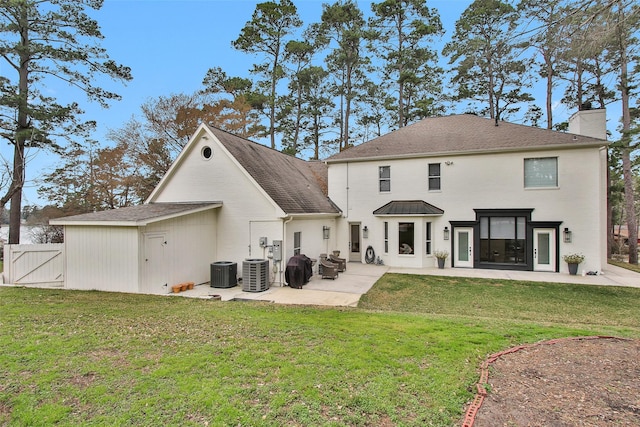 rear view of property featuring cooling unit, a yard, and a patio