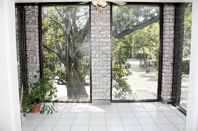 doorway to outside with a wall of windows and tile patterned flooring