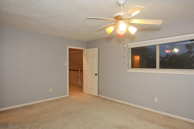 carpeted spare room featuring ceiling fan