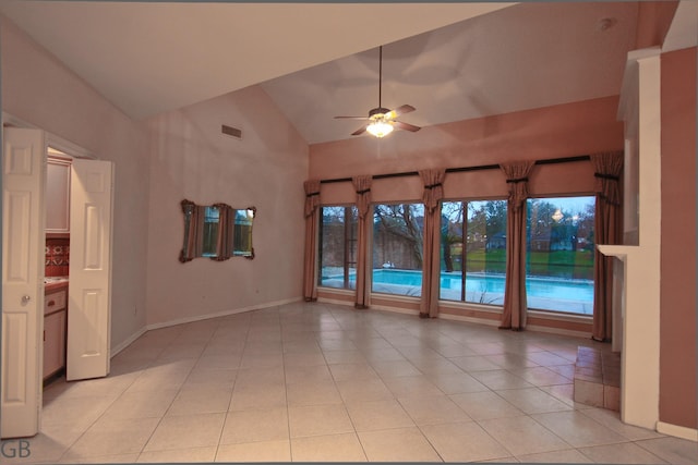 tiled empty room featuring vaulted ceiling and ceiling fan